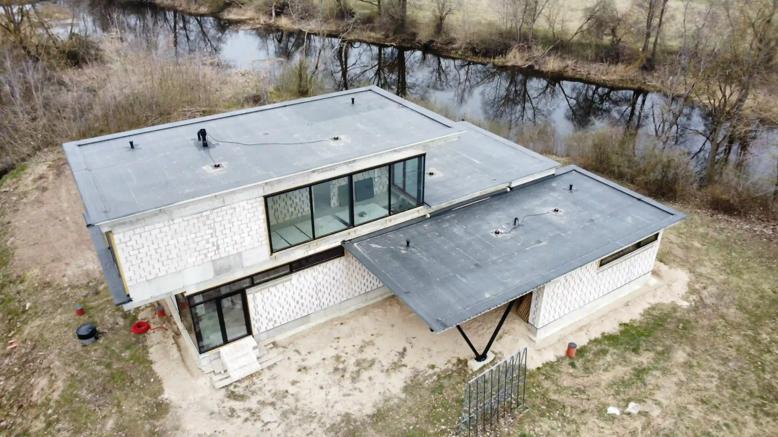 Modernus pastatas su EPDM stogo danga prie upės.
